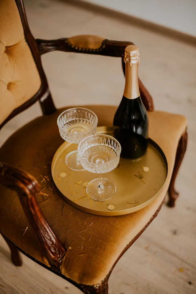 Champagne flutes catching backlight in a darkened room.